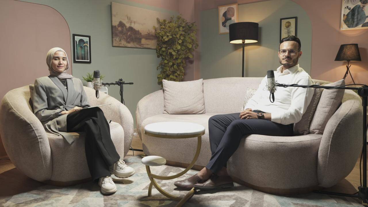 image of a man and a women setting the podcast show